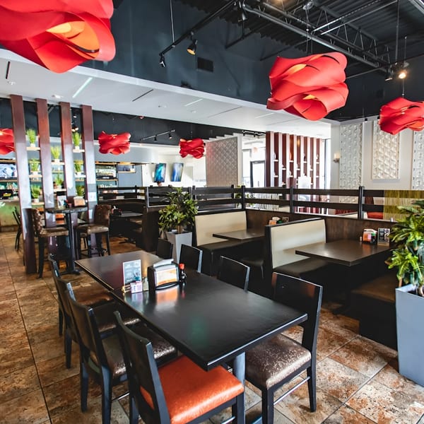 Zake's Asian-fusion restaurant interior with red light fixtures, dark tables, and booth seating.
