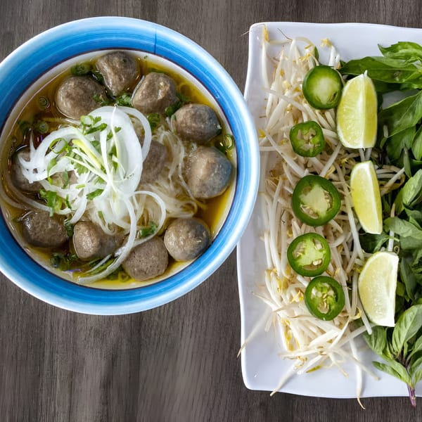 Zake's Asian-fusion beef pho with noodles, onions, and a side of bean sprouts, jalapeños, and lime.
