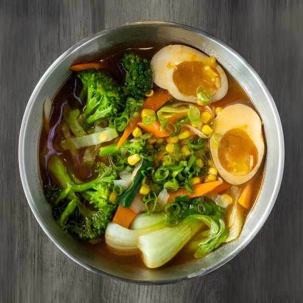 Zake's ramen bowl with broccoli, bok choy, carrots, corn, scallions, and two soft-boiled eggs.