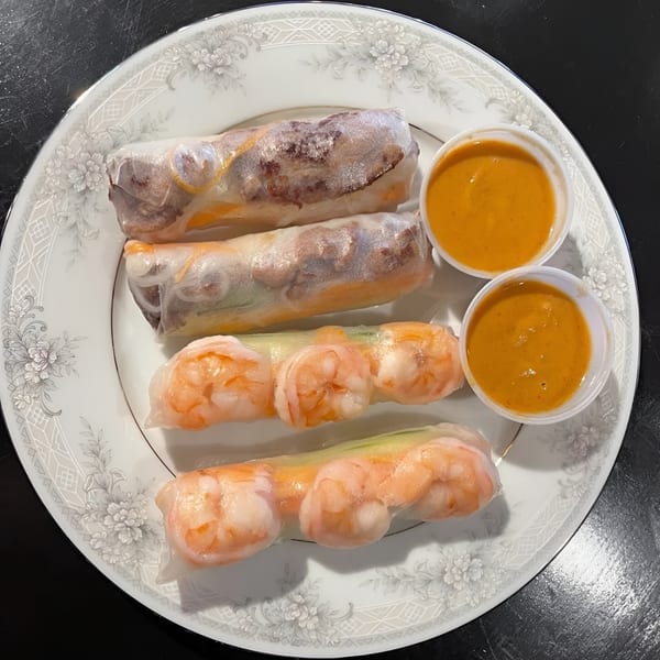 Zake's fresh spring rolls with shrimp and beef, served with two dipping sauces on a white plate.