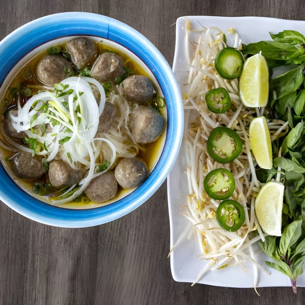 Zake's beef pho with meatballs, noodles, and onions, served with a side of bean sprouts, jalapeños, and lime.